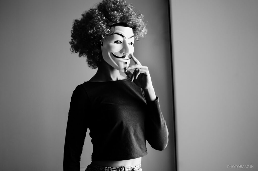 Girl with mask in front of her face.